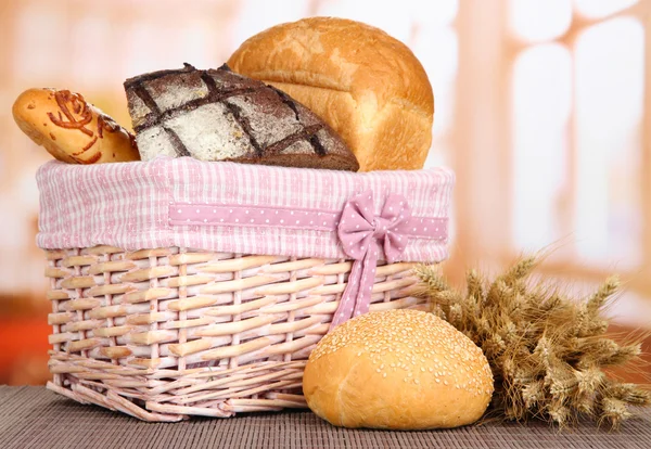 Baked bread in wicker basket on window background — Stock Photo, Image