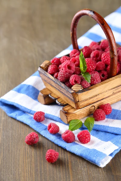 Ripe sweet raspberries in basket on wooden background — Stock Photo, Image