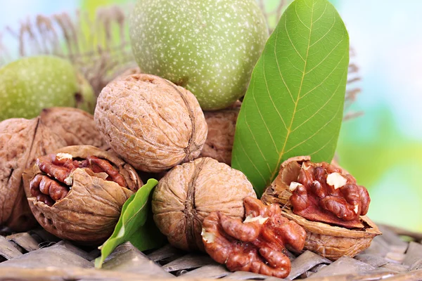 Walnuts with green leaves in garden, on green background — Stock Photo, Image