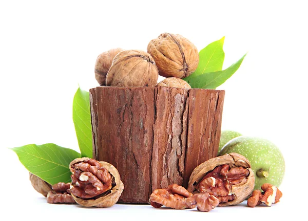 Vlašské ořechy se zelenými listy v woooden vázu, izolované na bílém — Stockfoto
