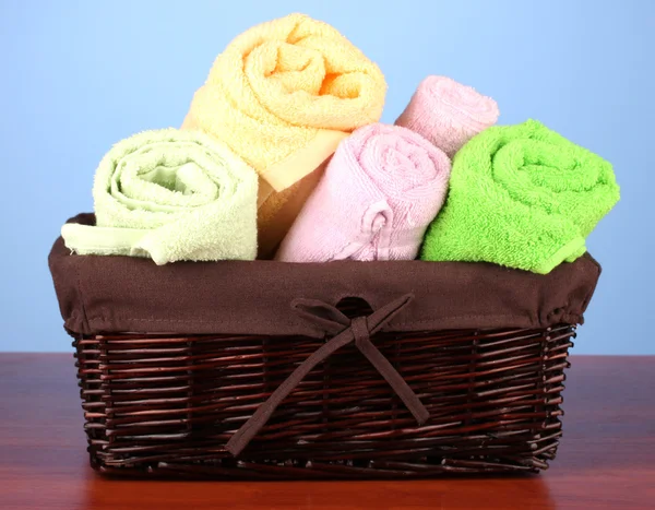 Fargerike håndklær i kurv på fargebakgrunn – stockfoto
