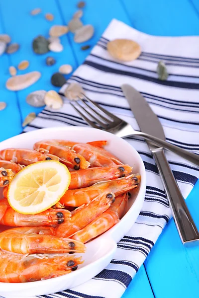 Crevettes avec citron sur assiette sur table en bois close-up — Photo