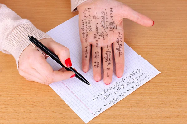 Γράψτε εξαπατήσει φύλλο στο χέρι σε κοντινό πλάνο ξύλινο τραπέζι — Φωτογραφία Αρχείου