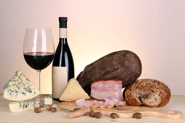 Exquisito bodegón de vino, queso y productos cárnicos — Foto de Stock