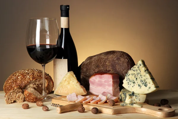 Exquisito bodegón de vino, queso y productos cárnicos — Foto de Stock