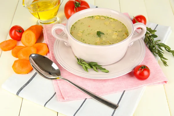 Nourishing soup in pink pan on wooden table close-up — Stock Photo, Image