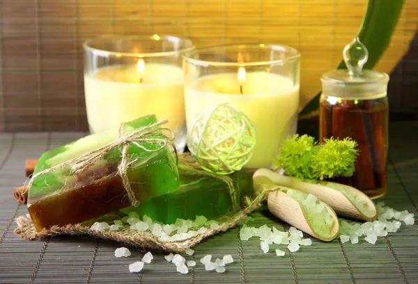 Jabón y velas hechas a mano sobre fondo de bambú — Foto de Stock