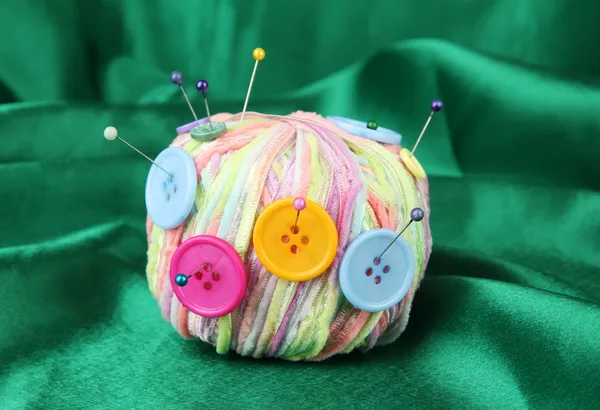 Boutons colorés et boule de laine multicolore, sur fond de tissu couleur — Photo