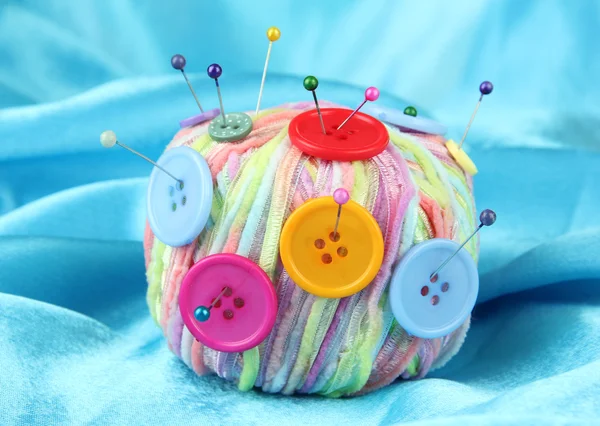 Colorful buttons and multicolor wool ball, on color fabric background — Stock Photo, Image