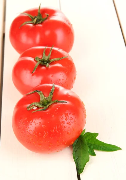 Tomates frescos sobre fundo de madeira branca — Fotografia de Stock