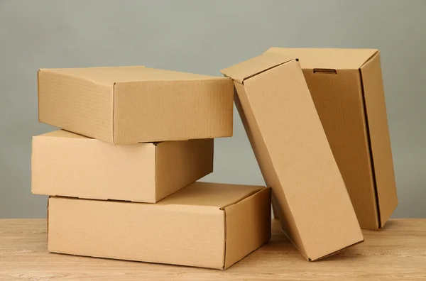 Cajas de paquetes sobre mesa de madera, sobre fondo gris — Foto de Stock