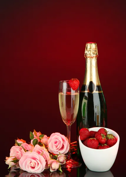 Romantic still life with champagne, strawberry and pink roses, on dark color background — Stock Photo, Image