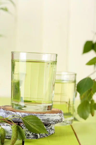 Brýle Březové mízy na zelený dřevěný stůl — Stock fotografie