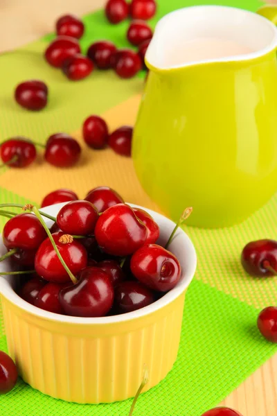 Ripe red cherry berries in bowl on wooden table close-up — Stock Photo, Image