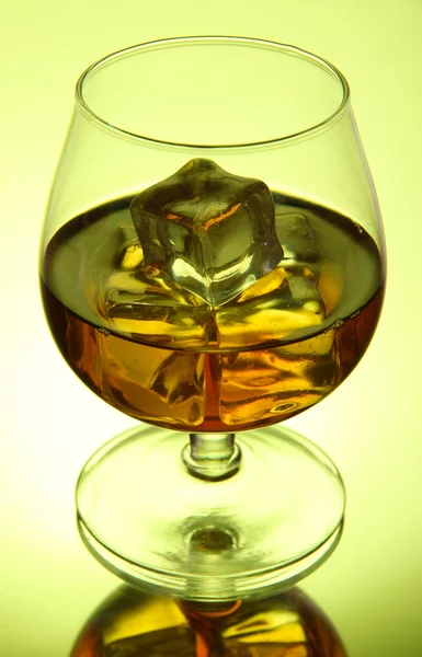 Brandy verre avec glace sur fond vert — Photo