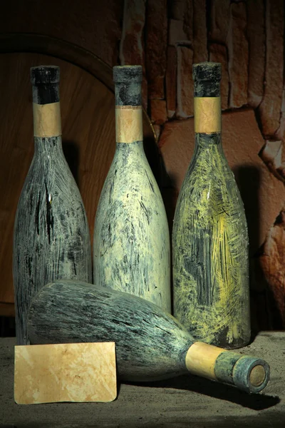 Viejas botellas de vino en bodega vieja, sobre fondo oscuro —  Fotos de Stock