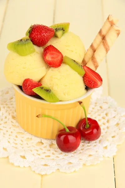 Delicioso helado con frutas y bayas en un tazón sobre una mesa de madera —  Fotos de Stock