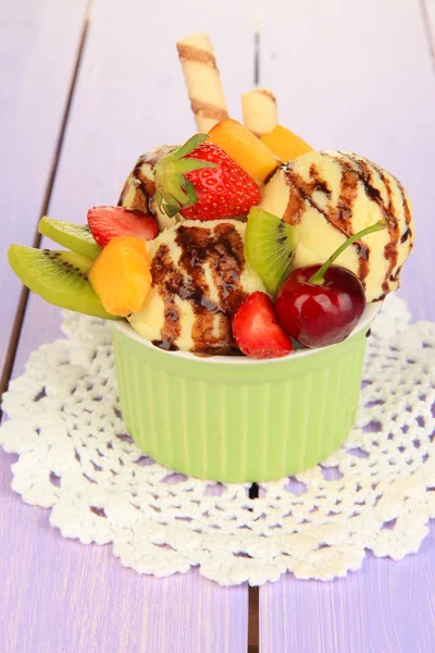 Delicioso helado con frutas y bayas en un tazón sobre una mesa de madera —  Fotos de Stock