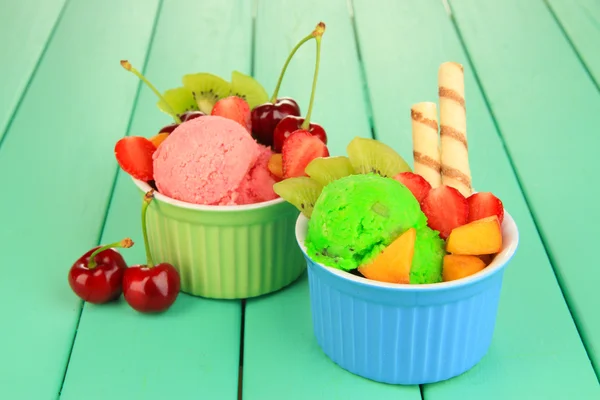 Délicieuse crème glacée aux fruits et baies dans un bol sur une table en bois — Photo