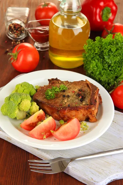 Stekt köttbit på plattan på träbord närbild — Stockfoto
