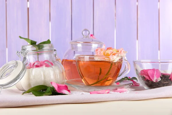 Bouilloire et tasse de thé de thé rose sur serviette sur fond en bois — Photo