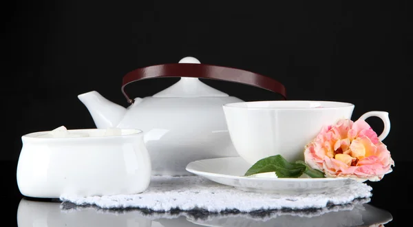 Hervidor de agua y taza de té de rosa de té sobre fondo negro servilleta —  Fotos de Stock