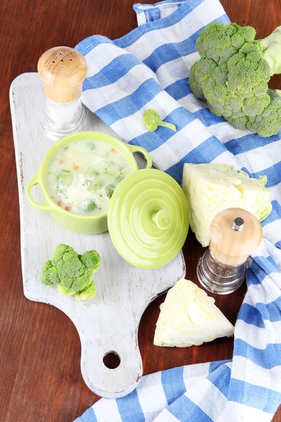 Cabbage soup in plate on board for cutting near napkin on wooden table — Stock Photo, Image