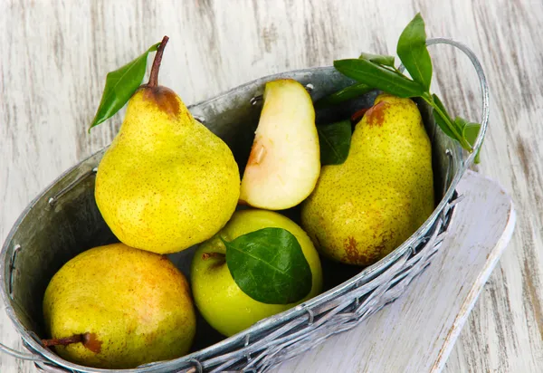 Pears in basket on board on wooden table — Stock Photo, Image