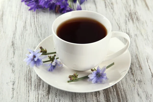 Cup of tea with chicory, on wooden background — Stock Photo, Image