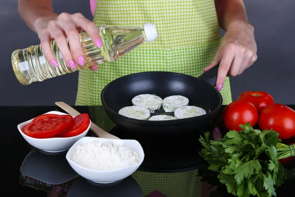 Manos cocinando calabacines en sartén sobre fondo gris —  Fotos de Stock