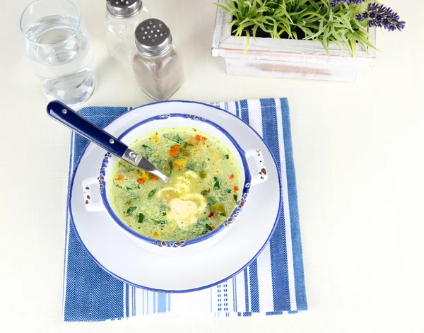 Суп в тарелке на салфетке на столе — стоковое фото