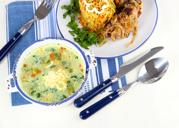 Soupe et riz avec viande dans des assiettes sur la serviette sur la table — Photo