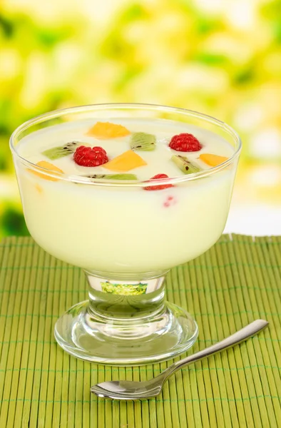 Iogurte delicioso com frutas na mesa em fundo brilhante — Fotografia de Stock