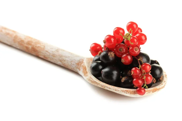 Röda och svarta vinbär i trä sked isolerad på vit — Stockfoto