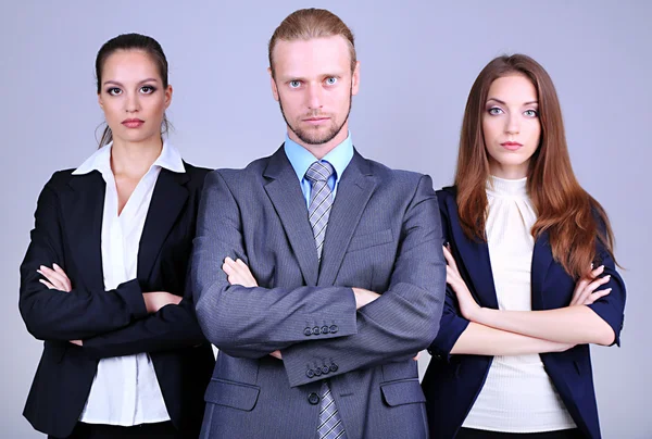 Geschäftsteam steht in Reihe auf grauem Hintergrund — Stockfoto