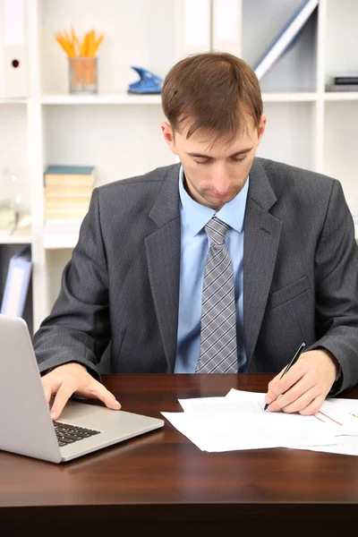 Young businessman in office at his workplace Royalty Free Stock Photos