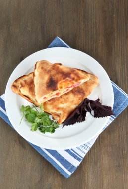 Pizza calzone peçete ahşap masa üzerinde plaka üzerinde