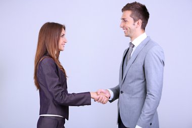 gri zemin üzerine el sıkışan iş arkadaşları
