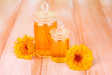 ilaç şişeleri ve ahşap zemin üzerine calendula çiçekler