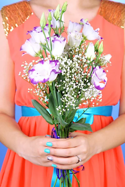 女人在蓝色的背景，持有的花束，特写 — 图库照片