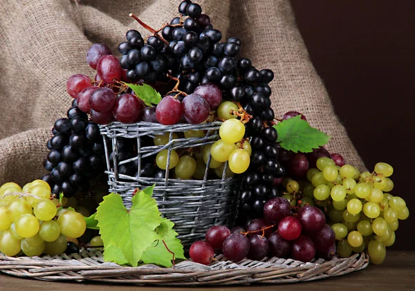 Surtido de uvas dulces maduras en cesta, sobre fondo marrón —  Fotos de Stock