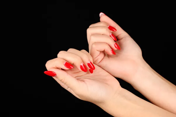 Mooie vrouwelijke handen met rode nagels geïsoleerd op zwart — Stockfoto