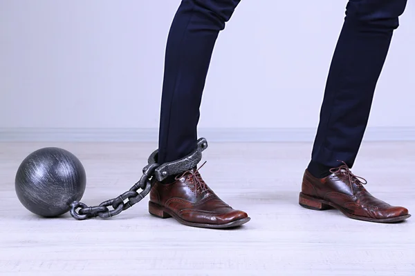 Business worker with ball and chain attached to foot — Stock Photo, Image