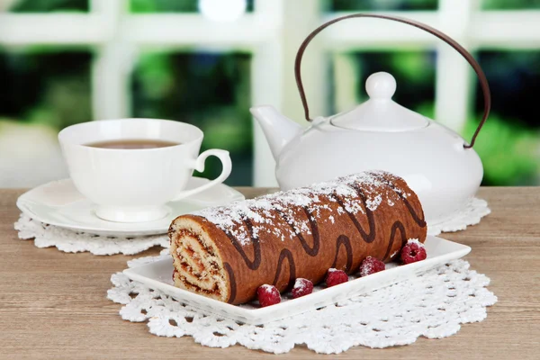 Rouleau sucré avec tasse de thé sur la table dans la chambre — Photo