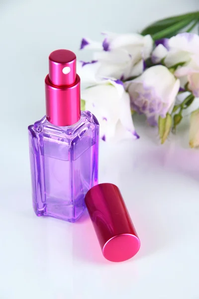 Parfüm in der Flasche und Blumen isoliert auf weiß — Stockfoto