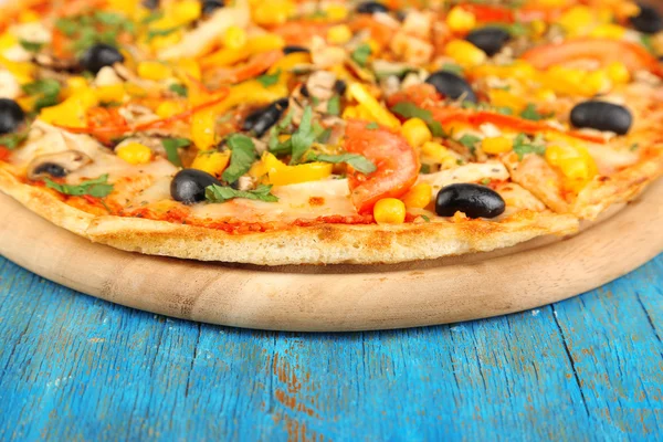 Gustosa pizza sul tavolo di legno blu primo piano — Foto Stock