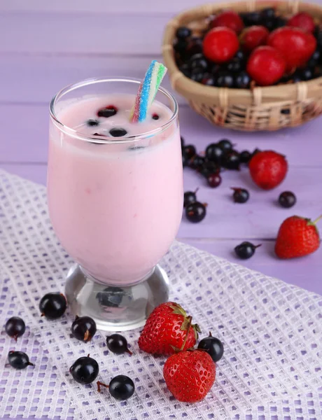 Delicious milk shake with blackberry and strawberries on wooden table close-up — Stock Photo, Image