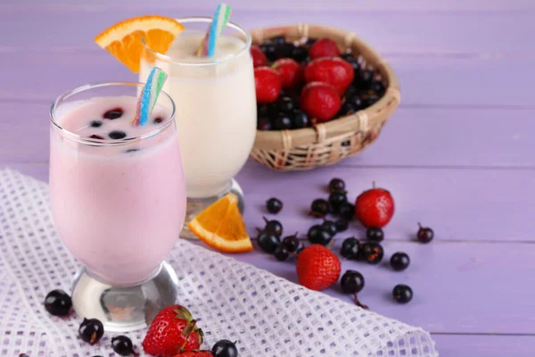 Delicious milk shakes with orange and blackberry on wooden table close-up — Stock Photo, Image