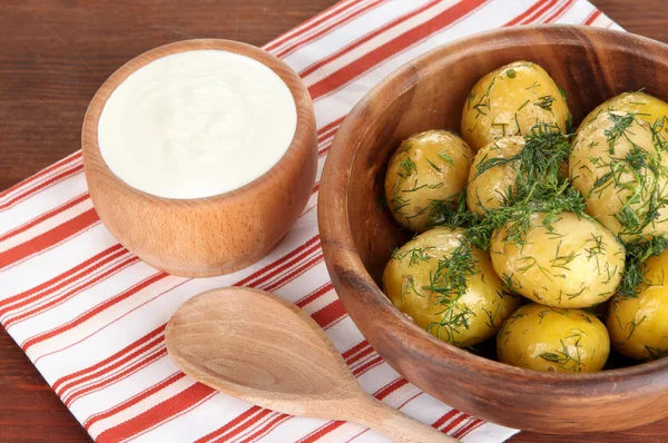 Patate bollite su ciotola di legno su tovagliolo su tavolo di legno — Foto Stock