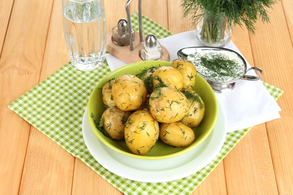 Boiled potatoes on platens on on napkins on wooden table — Stock Photo, Image